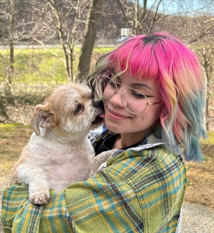 Tatiana, veterinary technician, holding a dog outdoors